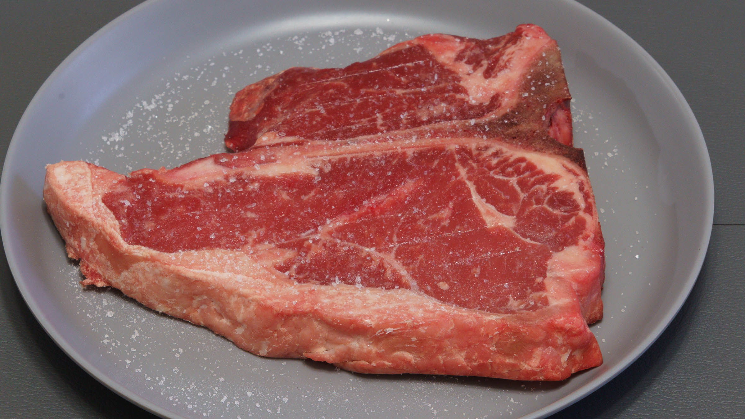 Dry-brined T-bone steak ready to be cooked.