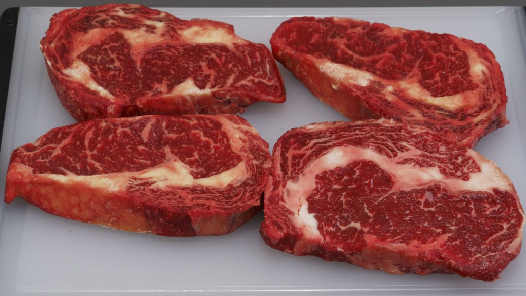 A cutting board with four scotch fillet steaks from a local state-based supermarket $AUD30/kilogram