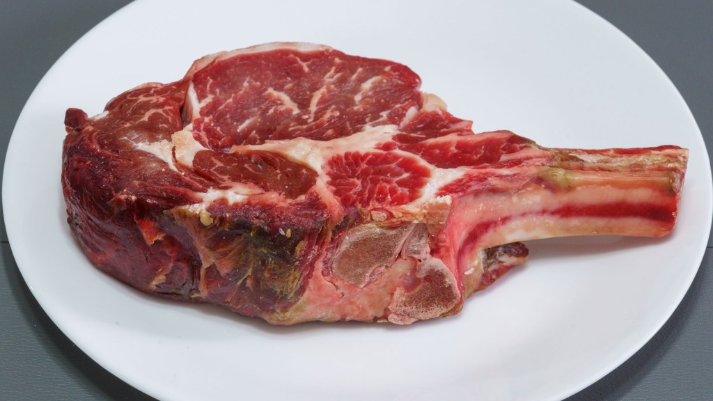 Photograph of dry brined bone-in ribeye steak.