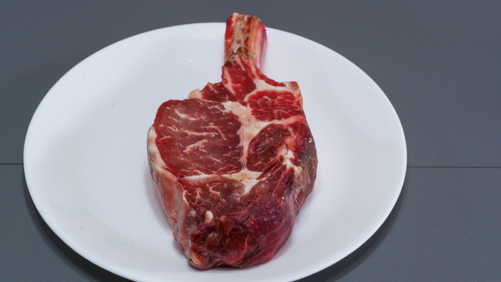 Photograph of dry brined bone-in ribeye steak.