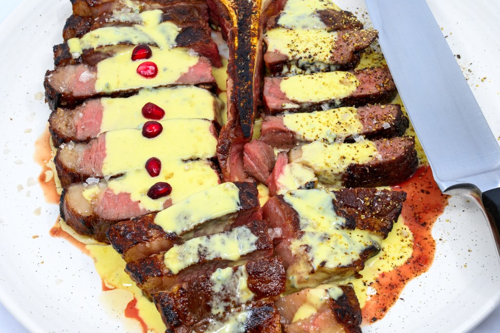 T-bone steak with blue vein cheese and mustard sauce with pomegranate arils