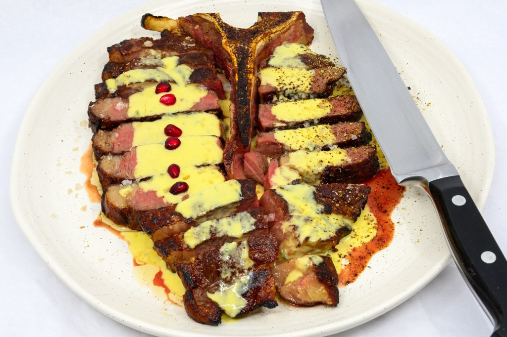 T-bone steak with blue vein cheese and mustard sauce with pomegranate arils
