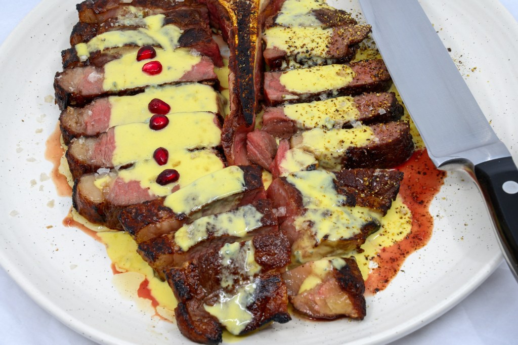 T-bone steak with blue vein cheese and mustard sauce with pomegranate arils