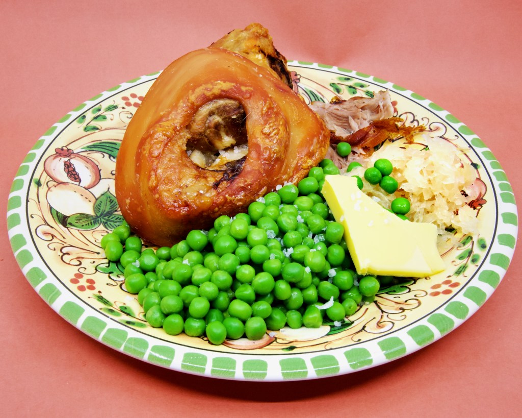 Pork knuckle with sauerkraut and peas
