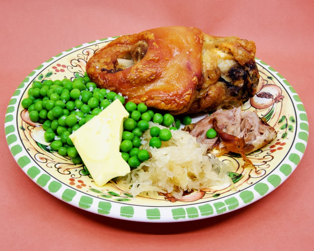 Pork knuckle with sauerkraut and peas