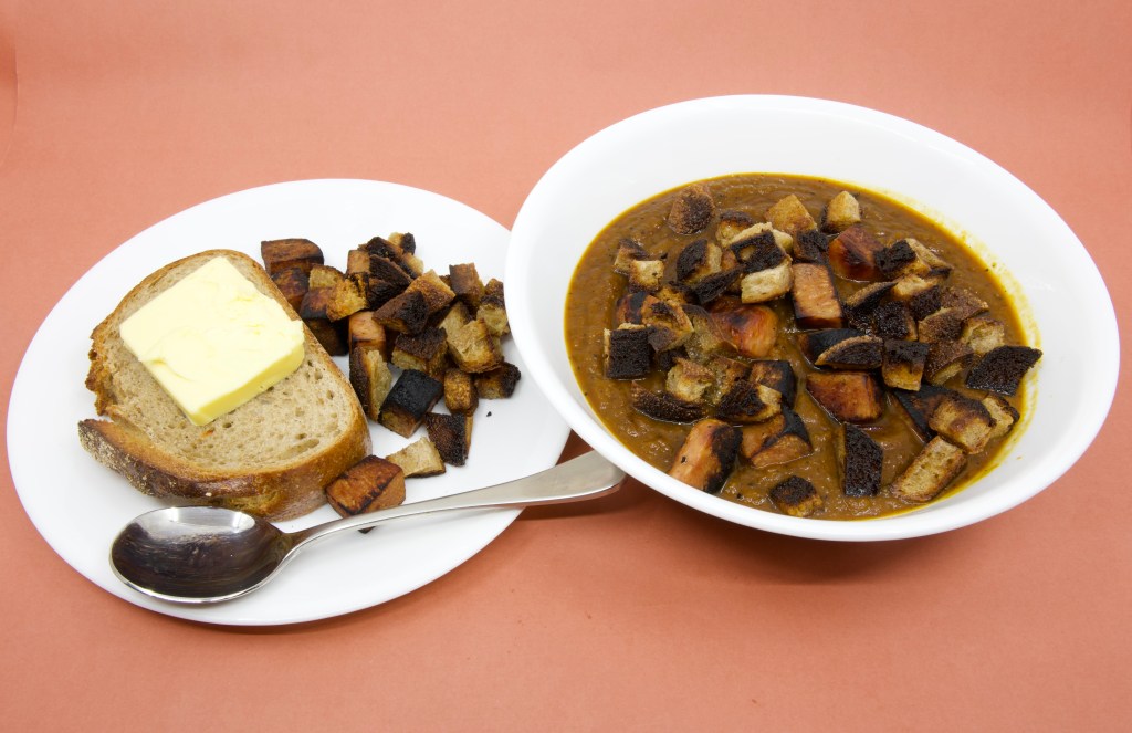 Pumpkin soup with Spam, rye sourdough croutons, and slice of rye sourdough with cultured butter
