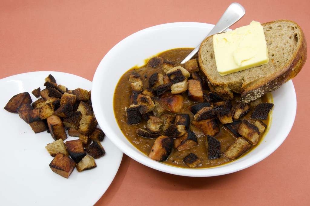 Pumpkin soup with Spam, rye sourdough croutons, and slice of rye sourdough with cultured butter