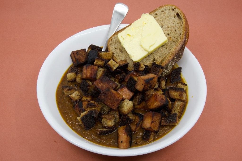 Pumpkin soup with Spam, rye sourdough croutons, and slice of rye sourdough with cultured butter