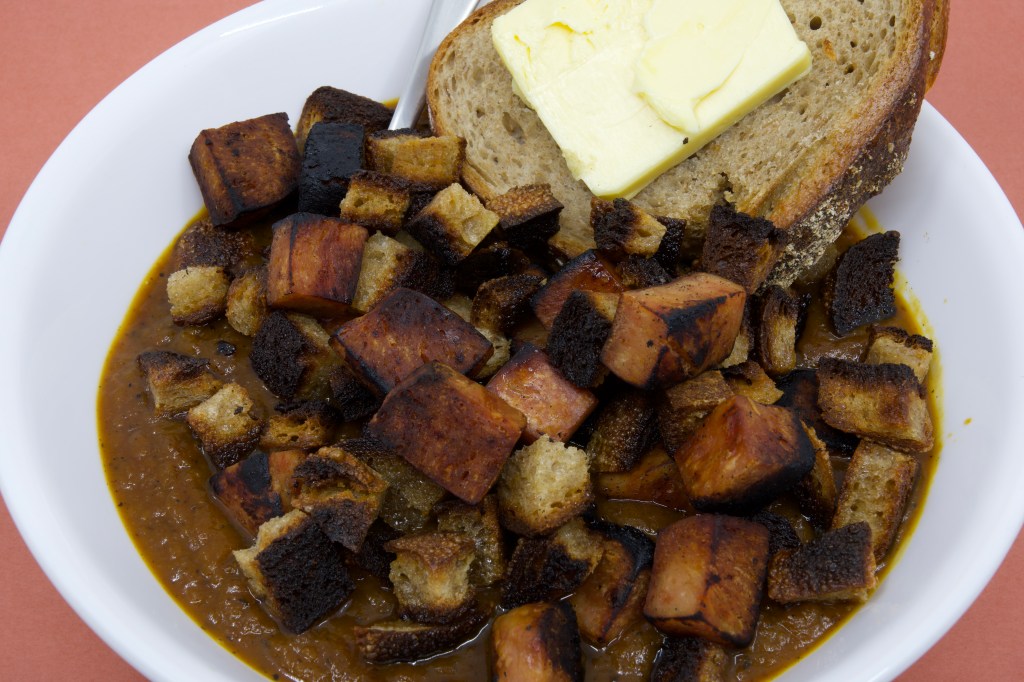 Pumpkin soup with Spam, rye sourdough croutons, and slice of rye sourdough with cultured butter