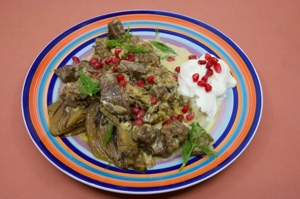 Beef short rib meat cooked in a pressure cooker and served with Greek-style yoghurt garnished with pickled pomegranate arils and fennel fronds.