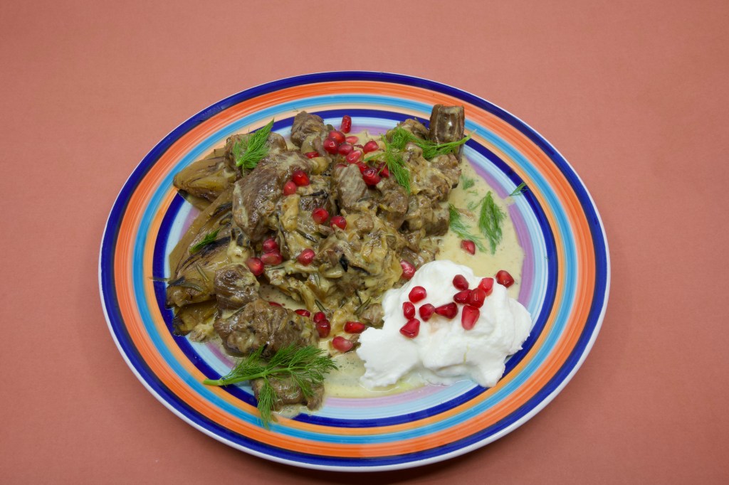 Beef short rib meat cooked in a pressure cooker and served with Greek-style yoghurt garnished with pickled pomegranate arils and fennel fronds.