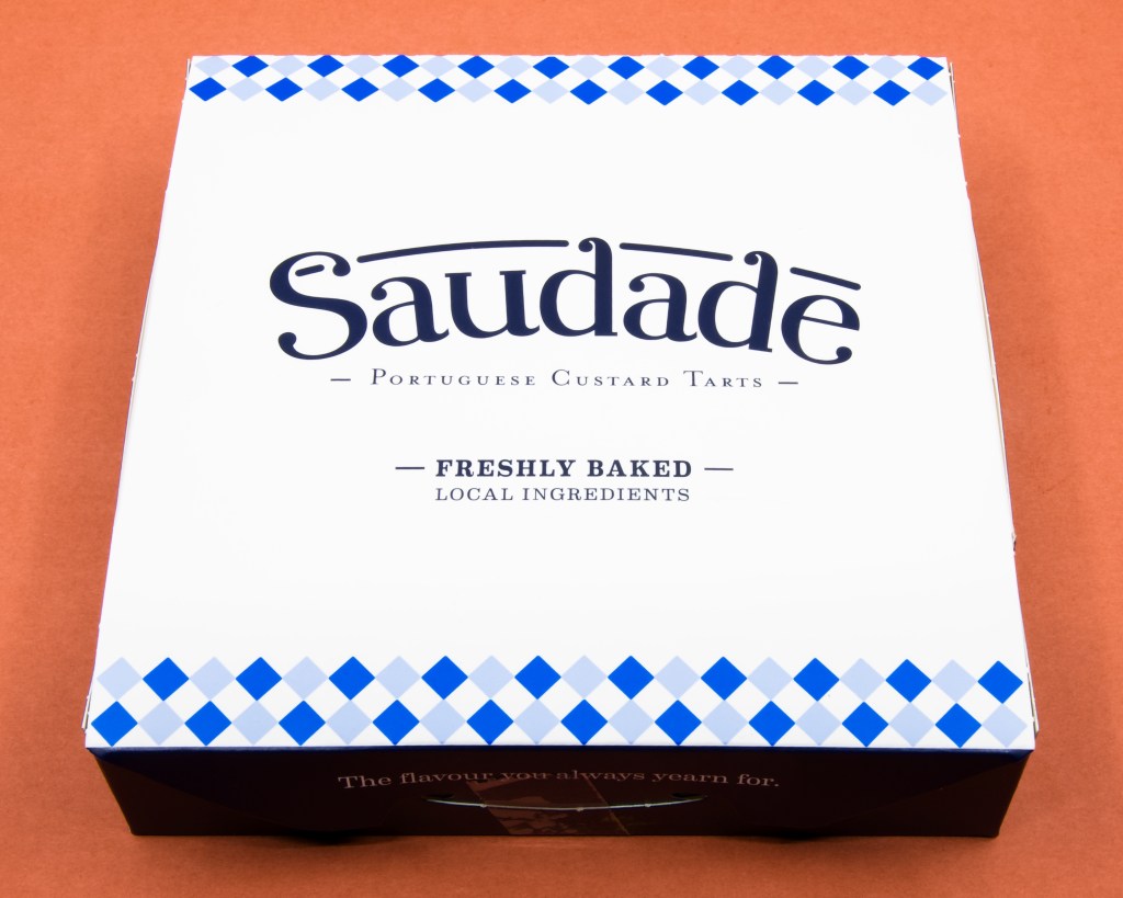 A photograph of the Saudade Portuguese custard tart box containing Portuguese custard tarts