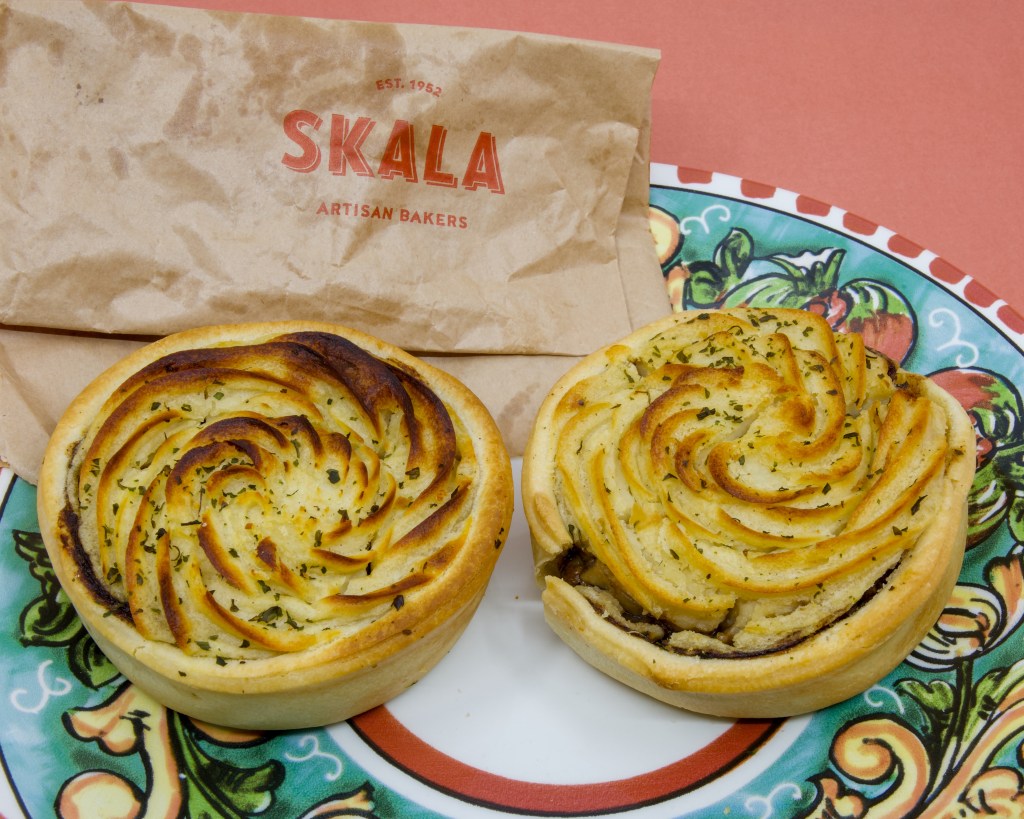 A photograph of a colourful plate with two potato pies from Skala Artisan Bakeries.