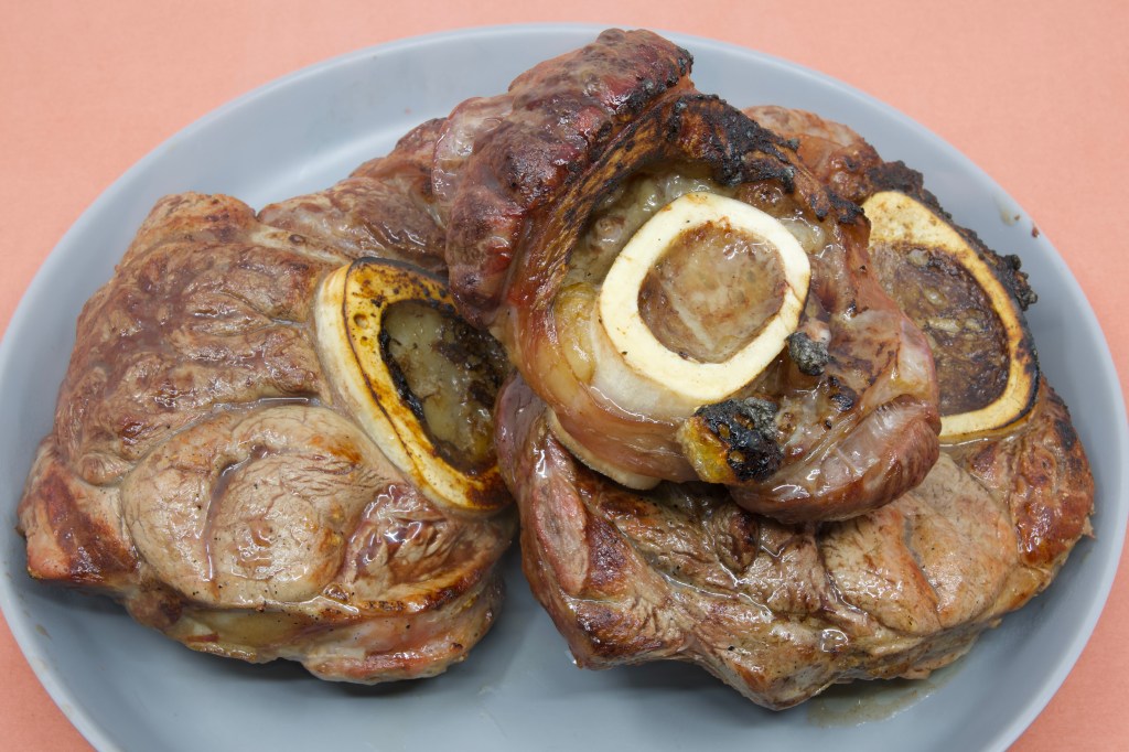 A photograph of seared beef shank straight out of the barbecue. The bone marrow is still in the bone.
