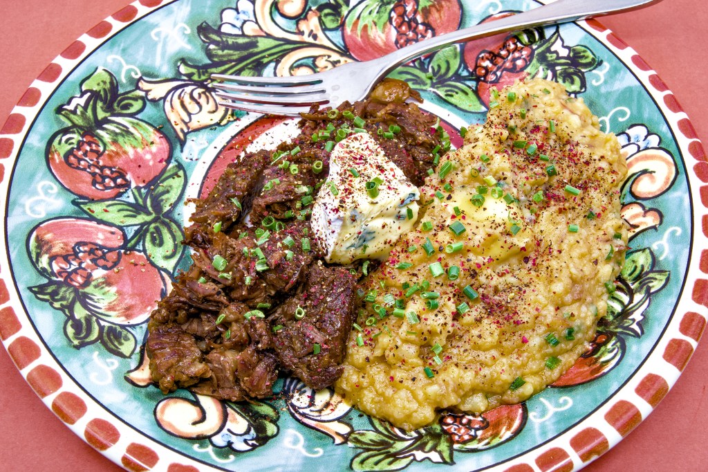 This dish features beef short ribs and potatoes, pressure-cooked and chilled overnight to develop their rich flavours. The beef is gently hashed in a skillet until perfectly tender, served alongside buttery, fork-mashed potatoes folded with creamy blue brie. Topped with an extra chunk of brie, chives, and cracked peppercorns for the perfect finish.